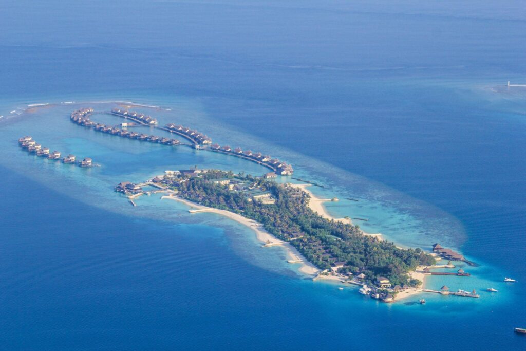 Aerial cinematic view of Maldives islands and tourism infrastructure representing the country’s economy.