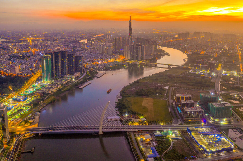 Ho Chi Minh City skyline at sunset with river, bridge, and skyscrapers showing Vietnam economic growth