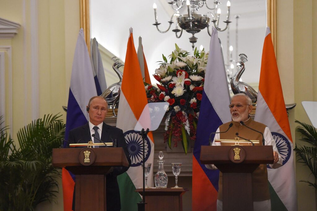 PM Narendra Modi and Vladimir Putin with Indian and Russian military assets representing the RELOS defence logistics pact