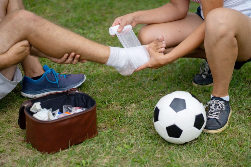 Medical staff treating an injured football player during a professional match