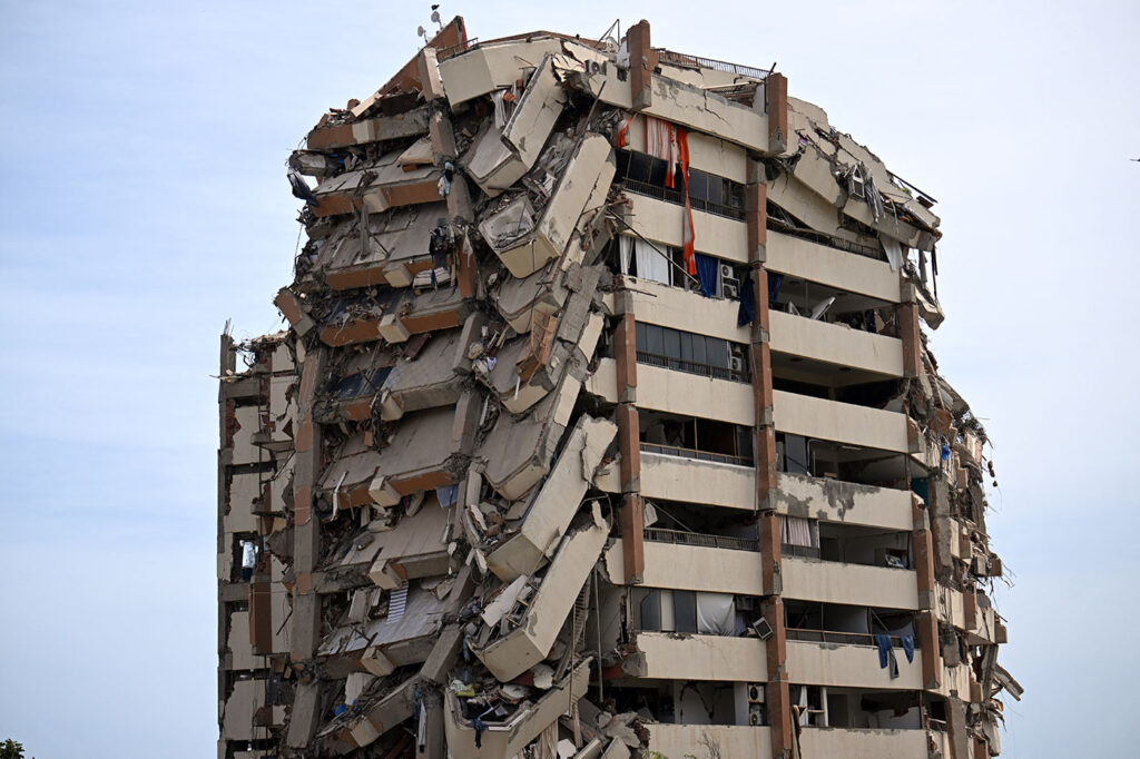 A heavily damaged high-rise apartment building stands partially collapsed after the devastating earthquakes in northern Venezuela.