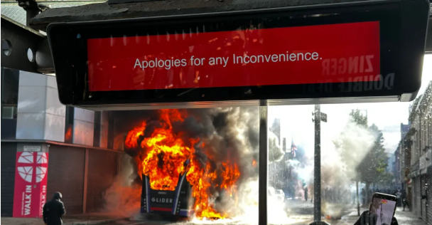 A public bus engulfed in flames on a Belfast street as thick black smoke rises into the air during unrest linked to anti-immigration riots in Northern Ireland.