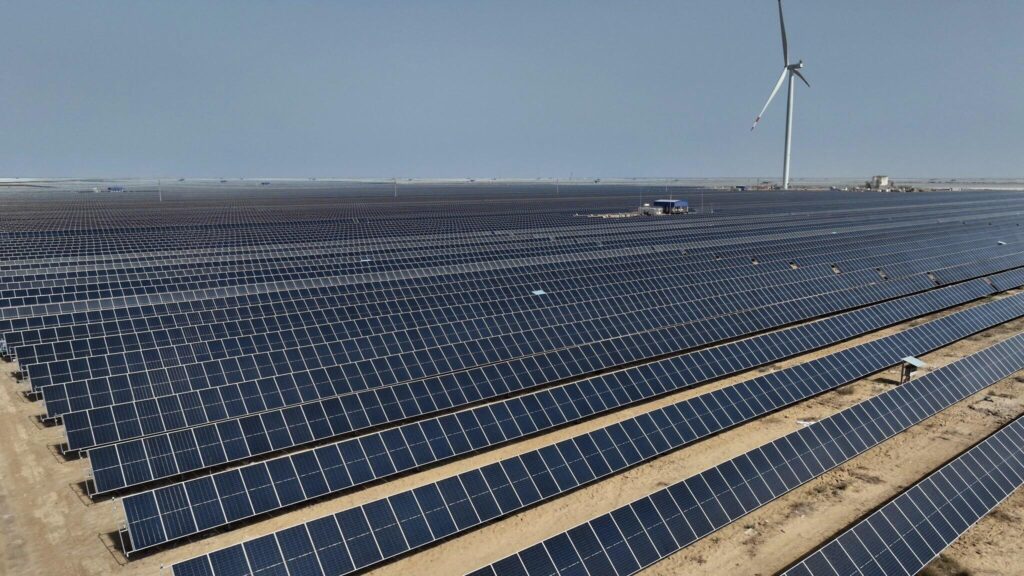 From Barren Desert to Renewable Energy Superpower: Inside India's $30 Billion Khavda Mega Project Aerial view of the Khavda Renewable Energy Park in Gujarat featuring vast solar panel arrays and wind turbines across the Kutch desert.