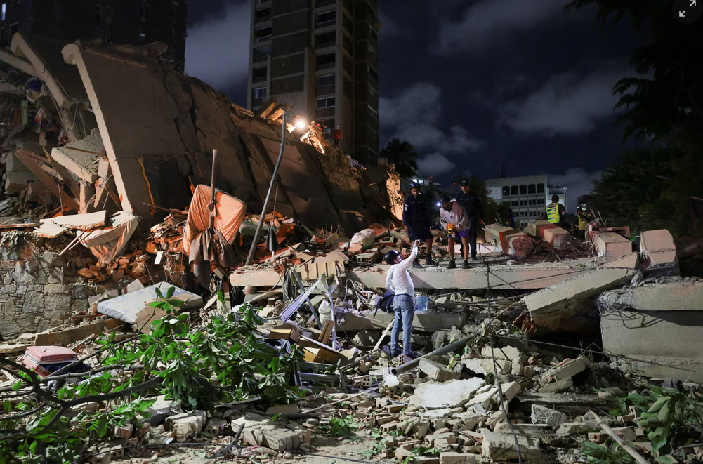 Rescue workers and residents search through the rubble of collapsed buildings overnight after the devastating Venezuela earthquake.