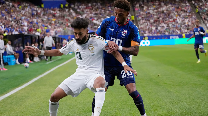 Nawaf Bu Washl shields the ball from Ryan Mendes during Cabo Verde vs Saudi Arabia