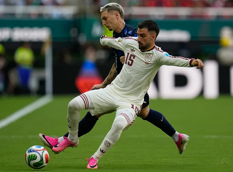 Guillermo Varela challenges Alex Baena for the ball during Uruguay vs Spain