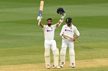 Ajinkya Rahane raises his bat and helmet after reaching a milestone for India in Test cricket