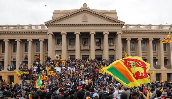 Sri Lankan protesters carrying national flags gather outside the Presidential Secretariat during the 2022 economic crisis