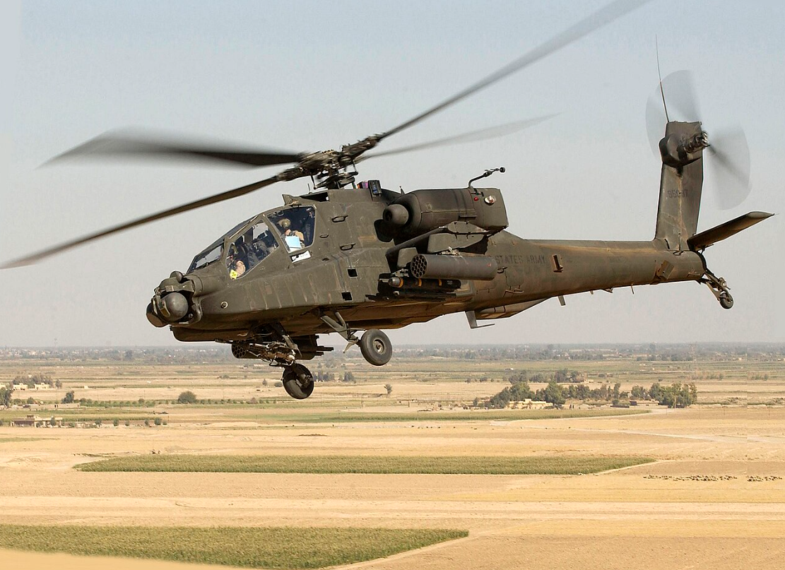 AH-64D Apache Longbow attack helicopter flying over desert terrain
