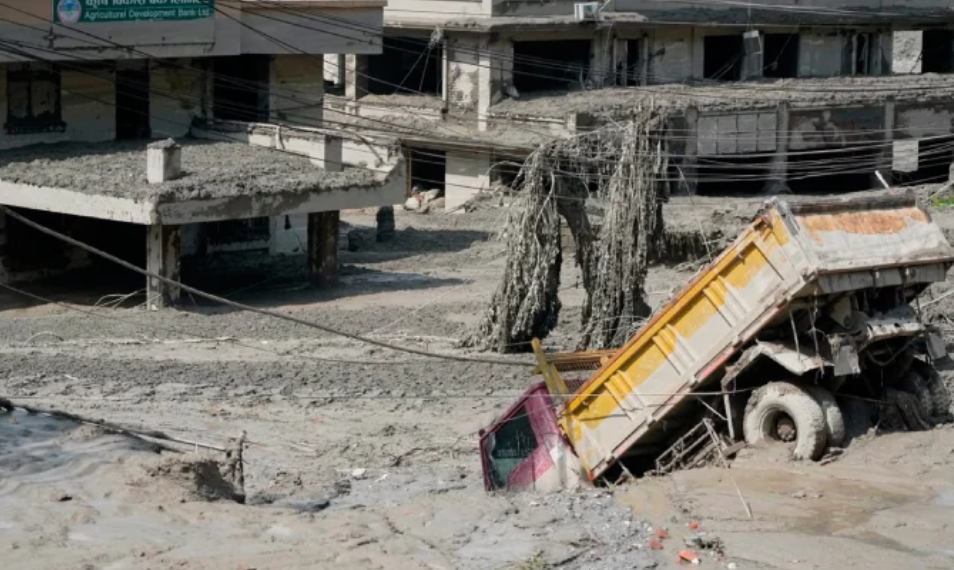 Buildings and a dump truck buried in mud and debris after severe flash floods in Nepal