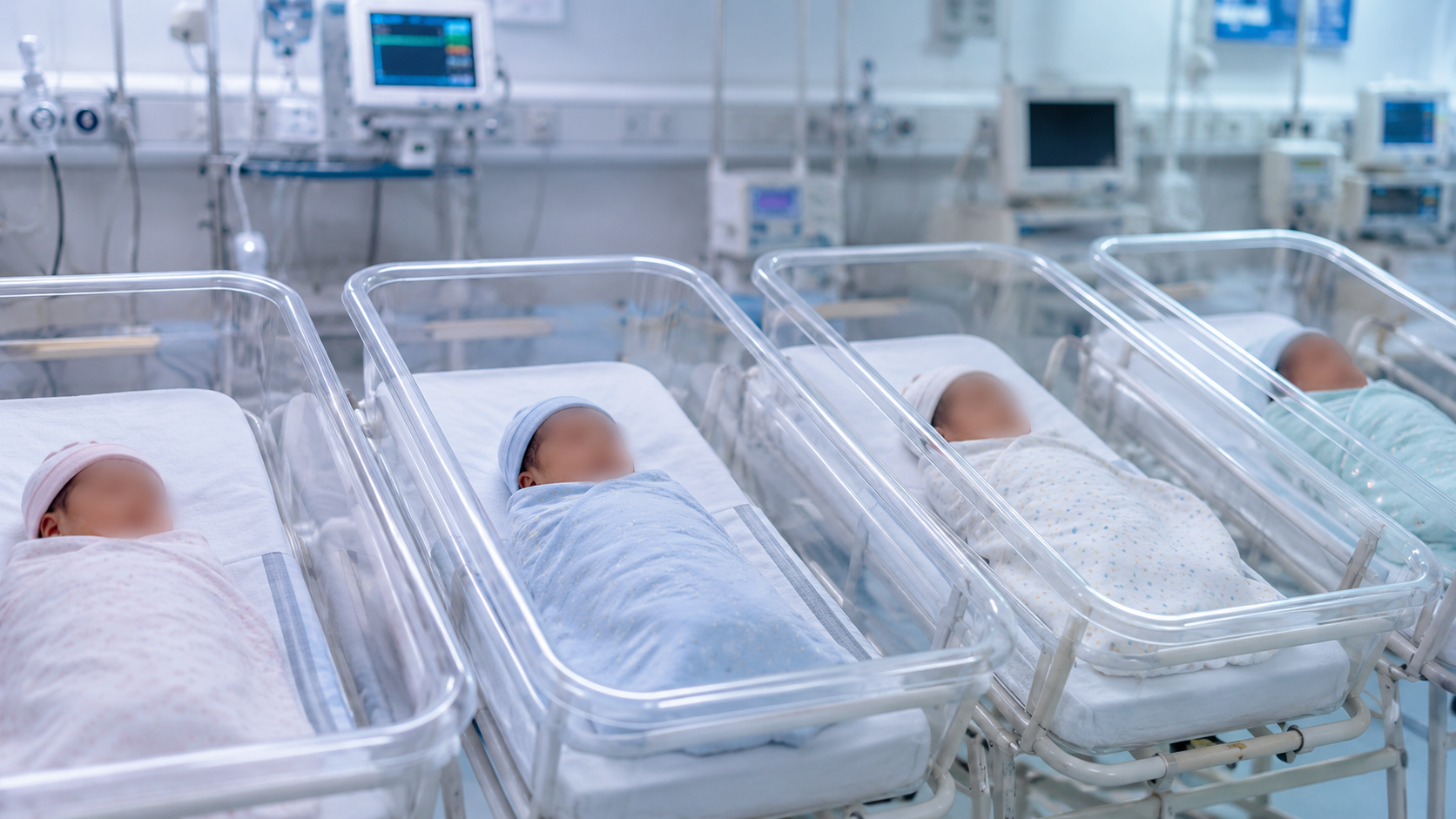 Representative image of newborn babies resting in separate hospital bassinets with their faces blurred