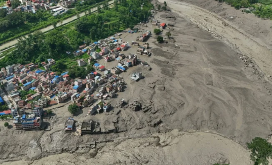 Aerial view of massive flood damage and mud deposits surrounding buildings in Nepal