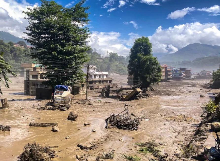 Mud-covered buildings, damaged vehicles and debris after a devastating flash flood in Nepal