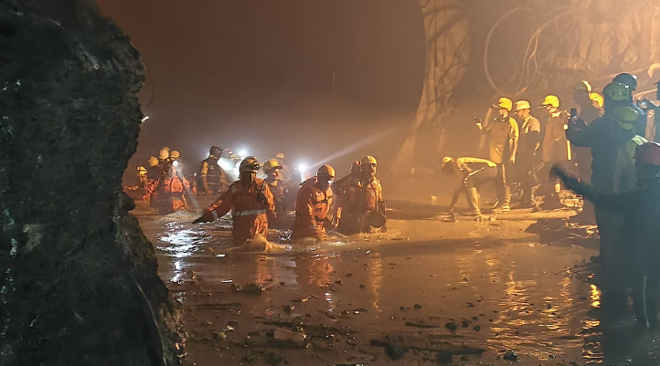 Rescue personnel working through water and debris inside the Vishnugad-Pipalkoti hydropower tunnel in Chamoli Uttarakhand
