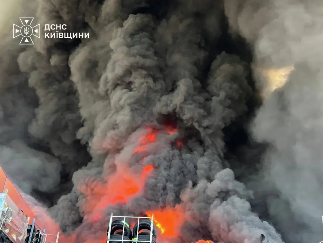 Firefighters respond as flames and thick smoke engulf a warehouse following a Russian drone strike near Kyiv