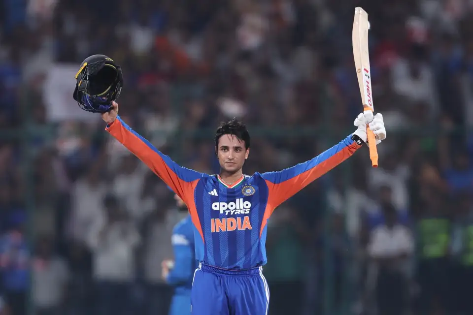 Abhishek Sharma raises his bat and helmet while celebrating his century against Afghanistan