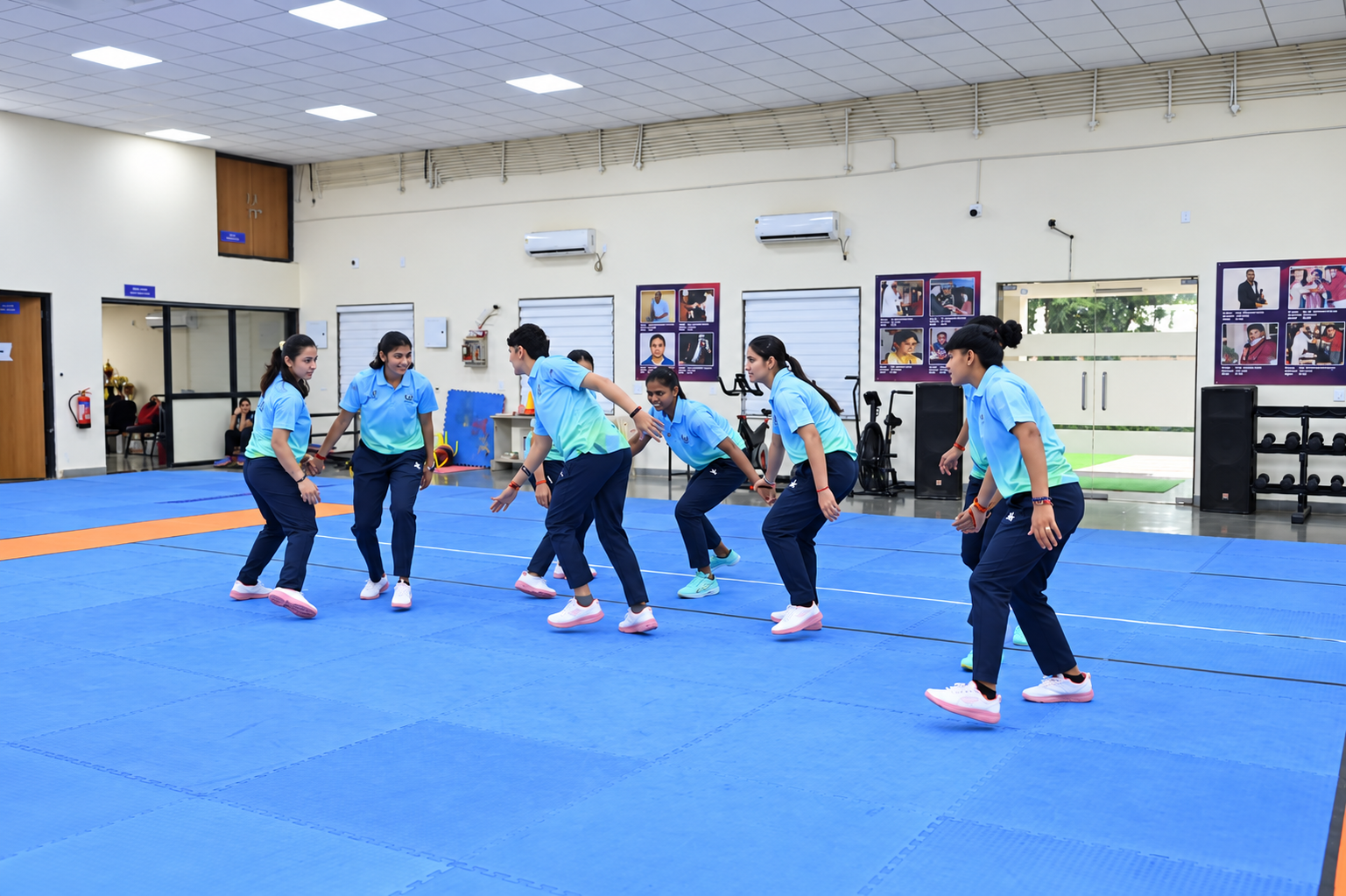 Indian women's kabaddi players practise defensive movement on an indoor mat