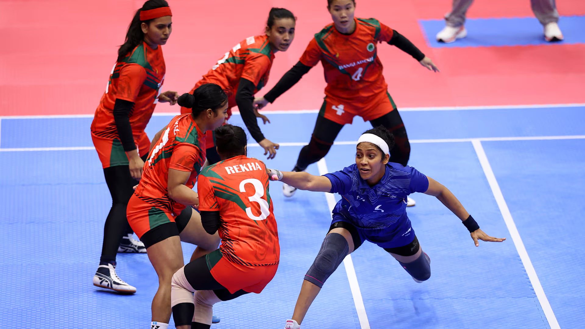 Indian women's kabaddi raider attempts a touch against Bangladesh defenders at the Asian Games 2026