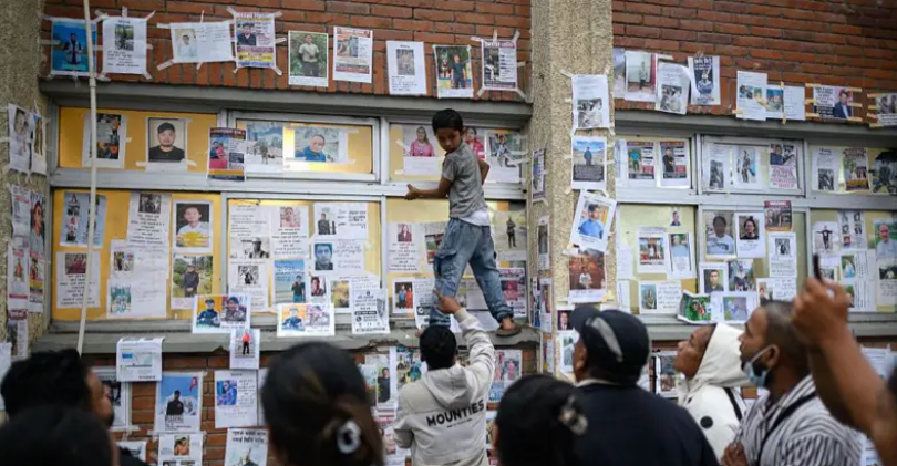 Photographs and notices of people missing after the Nepal floods cover a wall at Tribhuvan University Teaching Hospital in Kathmandu