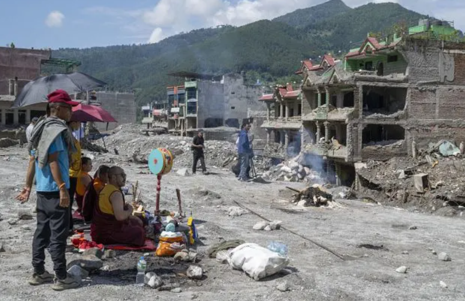 Residents stand among debris and damaged buildings in Nuwakot, Nepal, after the flash floods