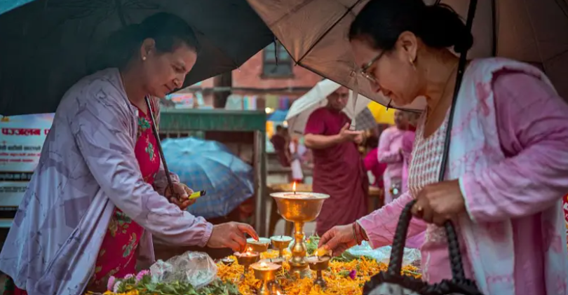 Women light oil lamps and place flowers during a vigil in Kathmandu for victims of the Nepal floods