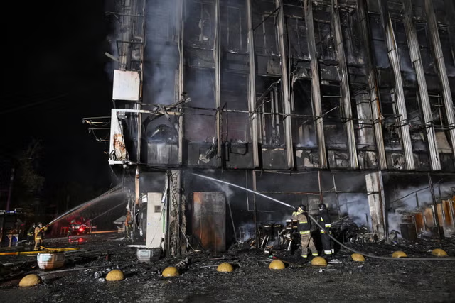 Ukrainian firefighters spray water on a heavily damaged building after a Russian attack in Zaporizhzhia.